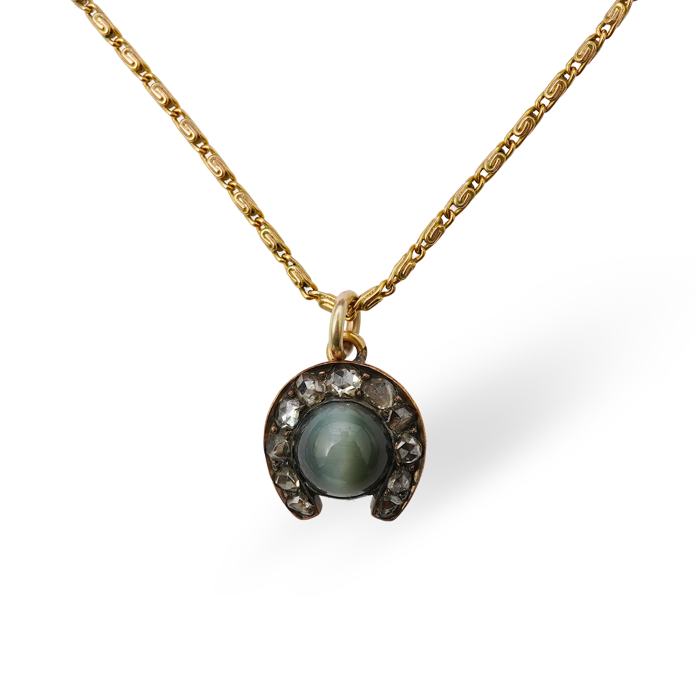A yellow metal, cat's eye quartz and rose cut diamond cluster set horseshoe pendent, 11mm, together with a 9ct gold chain, 41cm, gross weight 5 grams.